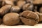 Brown coffee beans with white smoke vapour on yellow textured wooden board background close up.