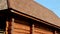 Brown colored log house with tar oiled cedar wooden shingle roof