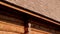 Brown colored log house wall with tar oiled cedar wooden shingle roof