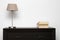 Brown commode with lamp and books in minimalism interior