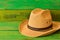 Brown cowboy hat on green wooden texture