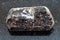 brown crystal of dravite tourmaline stone on dark