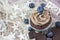 Brown cupcake with cream, many blueberries and chocolate