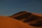 Brown dark Sahara desert slope at sunset