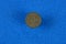 Brown denmark coin lying on a blue background