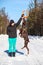 Brown doberman dog playing with a ring rubber toy while woman holding it on stretched hand