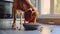 A brown dog eats from a bowl in a sunlit home kitchen