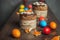 Brown Easter cakes decorated with chocolate, almond flakes and dried apricots among colored Easter eggs and tangerine zest on