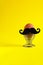 Brown egg with black moustache in metal helix egg cup on yellow empty background with copy space, concept for easter, breakfast,