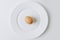 brown egg laying on white plate