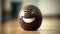 a brown egg with a smile on it\\\'s face on a wooden table with a blurry wall in the background and a door in the background.