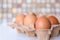 Brown eggs in a cardboard tray top view. Selected focus