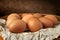 Brown eggs on a dark background. Raw brown chicken eggs on crumpled wrapping paper. High calorie protein food concept