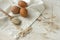 Brown eggs,dry oatmeal flakes on wooden spoon scattered over white linen cloth, wood background
