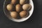 Brown eggs in enamel bowl own black rustic background
