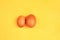 Brown eggs on yellow background. Size difference concept between two farm eggs