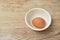 Brown eggshell in cup on wooden table