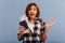 Brown-eyed girl throws up her hands in surprise. Snapshot of lady with short hairdo with travel documents in blue studio