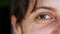 Brown eyes of an adult laughing woman close-up. Wrinkles around eyes of an attractive girl.