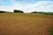 Brown farmer field under blue sky.