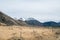 Brown field with Mountain backdrop in cloudy day, New Zealand