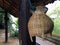 brown fish trap made from bamboo woven for storage aquatic animals hanging on wooden pole in space area under Thai house