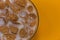 Brown flakes on a plate. On an orange background. Close up.