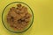 Brown flakes on a plate. On a yellow background. Top view