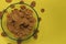 Brown flakes on a plate. On a yellow background. Top view