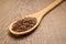 Brown Flax seed. Spoon and grains over wooden table.