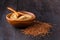 Brown flax seeds on spoon and flaxseed oil in glass jug on wooden table. Flax oil is rich in omega-3 fatty acid.