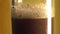 Brown foaming drink kvass or beer in a glass, vials of foam burst