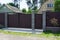 brown gate and part of a fence made of metal and bricks