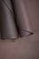 Brown genuine leather roll.real leather set. Leather in rolls on a blurred brown leather surface.Hobby and craft