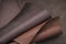 Brown genuine leather roll.real leather set. Leather in rolls on a blurred brown leather surface.Hobby and craft