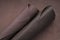 Brown genuine leather roll.real leather set. Leather in rolls on a blurred brown leather surface.leather texture