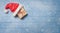 Brown gift box with santa hat on blue wooden table covered with snow - panorama