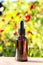 Brown glass dropper bottle with serum, essential oil or other cosmetic product on bright floral background. Natural Organic Spa
