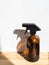 Brown glass spray bottle on wooden shelf on bright background. Copy space