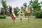 Brown, green and yellow birdhouses standing on green grass