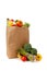 Brown grocery sack full of vegetables on white