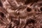 Brown hair texture. Wavy long curly light brown hair close up as background. Hair extensions, materials and cosmetics, hair care.