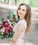 Brown-haired bride holds rich wedding bouquet