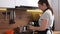 Brown-haired woman prepares food for family in kitchen