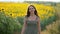 Brown-haired woman walks past huge field of sunflowers