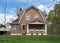 Brown House with Gambrel Roof in Springtime