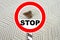 Brown insect, Clothes moth, sitting on a white woolen sweater, selective focus, red STOP sign, pest concept, destruction and