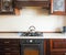 Brown kitchen with white worktop and gas stove