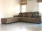 Brown L-shape sofa with cushion made from flower fabric