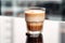 Brown latte in a glass, a delicious morning beverage